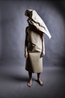 Young woman wearing a dress made of wrapping paper, a piece of paper covers her head, studio shot, Germany, Europe