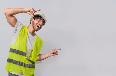 Builder engineer pointing finger to the right isolated, Construction engineer with vest pointing at an advertisement. Engineer man pointing to side. Smiling engineer man pointing aside