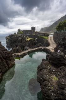 Natural volcanic rock pools, rocky coastline, Piscinas Naturais Velhas, Aquarium Aquario da Madeira in the back, Porto Moniz, Madeira, Portugal, Europe