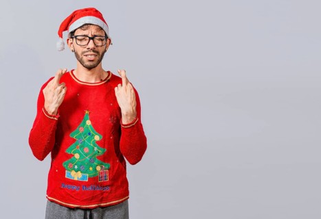 Guy with christmas hat making a wish on isolated background, Hopeful man in christmas clothes making a wish, Handsome man in christmas hat making a wish on white background