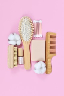 Eco friendly wooden beauty and hygiene products like comb and soap arranged on pink background