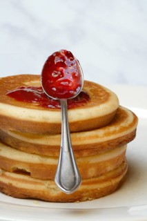 Pancake with raspberry jam and spoon