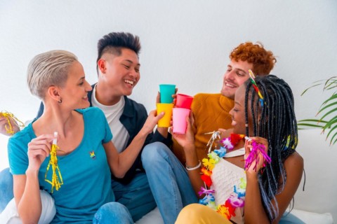 Lgtb couples of gay boys and girls lesbian in a portrait on a sofa at a house party, at a birthday party