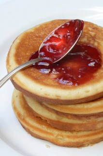 Pancake with raspberry jam and spoon