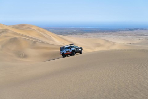 Off-road vehicle in sand dunes above the Orange River, also Oranjemund, Sperrgebiet National Park, also Tsau ÇKhaeb National Park, Namibia, Africa