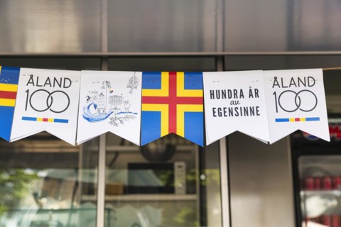 Various pennants for the anniversary, inscription 100 years of stubbornness, autonomy, flag Aland, Mariehamn, Aland Islands, Finland, Europe