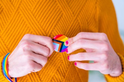 Metal badge with lgbt flag on lapel of man or woman suit
