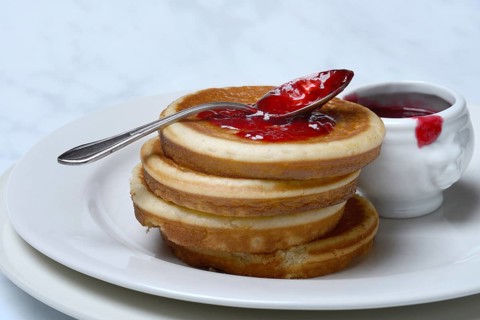 Pancake with raspberry jam and spoon