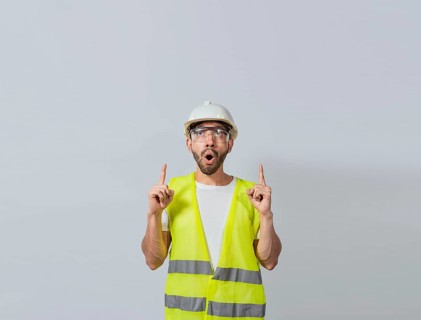 Surprised young architect pointing up, Amazed engineer pointing at an advertisement. Concept of an engineer with astonished face pointing at blank space, Amazed engineer man pointing up