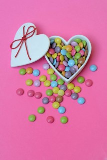 Chocolate lentils in heart-shaped container, Smartie