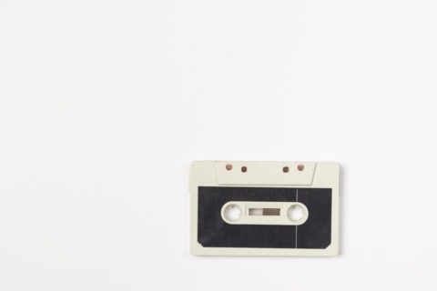 Old compact cassette on white background, copying room