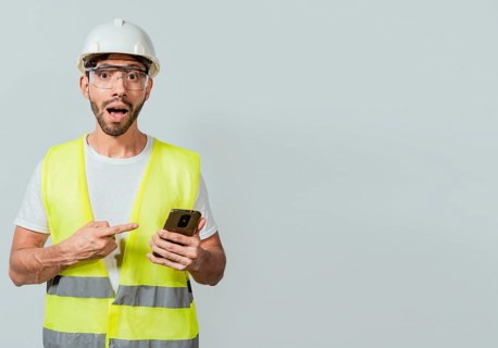 Engineer using and pointing at cellphone. Amazed construction worker using and pointing cellphone. Surprised face engineer using cell phone. Construction engineer pointing at phone promo