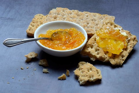 Orange marmalade in small bowls and on crispbread