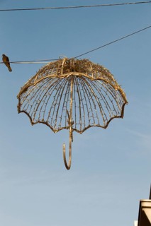 Beautiful umbrella of golden color hanging in the street for decorative purposes