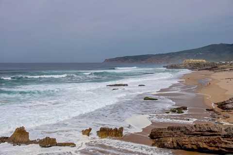Praia da Cresmina, in the background Fortaleza do Guincho, today a 5 star hotel, near Cascais Portugal