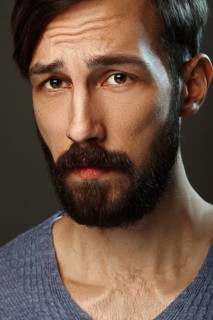 Closeup portrait of surprised man with beard and mustache looking worried