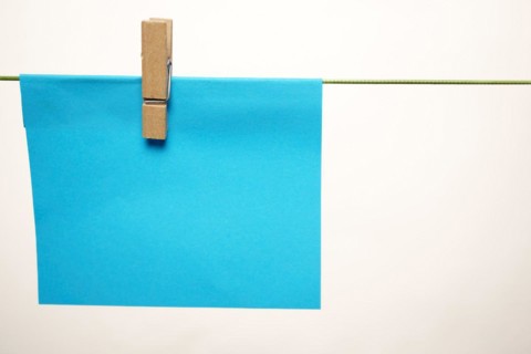 Sticky note hung with a clothespin on a clothesline with copy space and white background