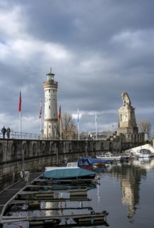 Lion pier with boats and Bavarian lion, in the back New Lindau lighthouse, Lindau harbour entrance, Lindau island, Lake Constance, Bavaria, Germany, Europe
