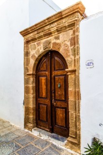 Old wooden doors with pebble mosaics on the floor, winding streets with white houses, Lindos, Rhodes, Greece, Europe