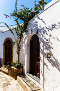 Old wooden doors with pebble mosaics on the floor, winding streets with white houses, Lindos, Rhodes, Greece, Europe