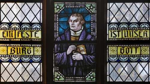 Portrait of Luther as a stained glass window with the words Eine feste Burg ist unser Gott, Evangelische Jakobuskirche, Breckerfeld, North Rhine-Westphalia, Germany, Europe