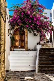Old wooden doors with pebble mosaics on the floor, winding streets with white houses, Lindos, Rhodes, Greece, Europe
