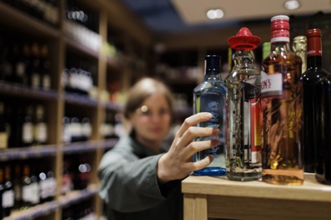Young woman, buying alcoholic beverages at the supermarket. Radevormwald, Germany, Europe