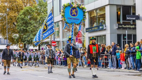 Festival procession, entry of the Wiesnwirte, Trachtler with flag and motif panel of the Loewenbraeufest tent, Oktoberfest, Munich, Upper Bavaria, Bavaria, Germany, Europe