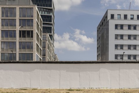 The Berlin Wall looms in front of newly built houses at the East Side Gallery in Berlin, 26.06.2022., Berlin, Germany, Europe