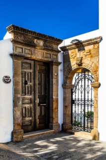 Old wooden doors with pebble mosaics on the floor, winding streets with white houses, Lindos, Rhodes, Greece, Europe