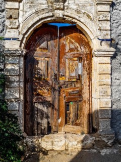 Old wooden doors with pebble mosaics on the floor, winding streets with white houses, Lindos, Rhodes, Greece, Europe