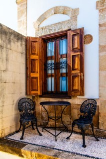 Sitting area with pebble mosaics on the floor, winding alleys with white houses, Lindos, Rhodes, Greece, Europe