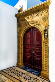 Old wooden doors with pebble mosaics on the floor, winding streets with white houses, Lindos, Rhodes, Greece, Europe