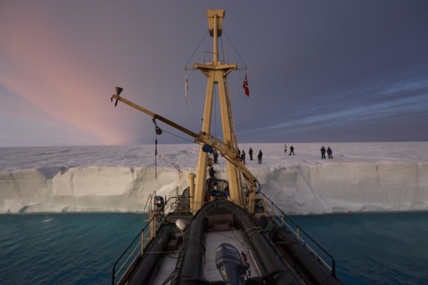 Expedition ship at the glacier front of the Brasvellbreen coastal glacier, behind passengers on the glacier, Nordaustlandet, Svalbard