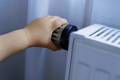 Bonn. Toddler turns the heating thermostat. Bonn, Germany, Europe