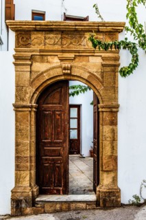 Old wooden doors with pebble mosaics on the floor, winding streets with white houses, Lindos, Rhodes, Greece, Europe
