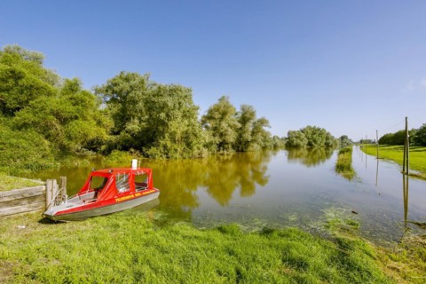 Flooding after heavy rain in North Rhine-Westphalia in the nature reserve at the Grietherorter and Bienener Altrhein, road flooded, boat of the fire brigade Rees, Rees, North Rhine-Westphalia, Germany...