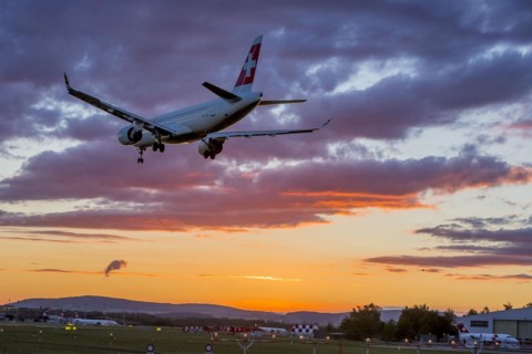 ZRH Airport with aircraft on approach of the airline Swiss, Bombardier BD-500, sunset, Zurich, Switzerland, Europe