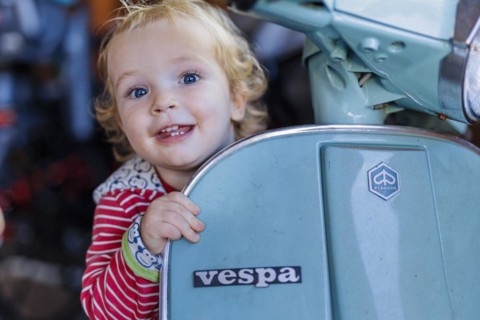 Little boy playing with a Vespa. Bonn, Germany, Europe
