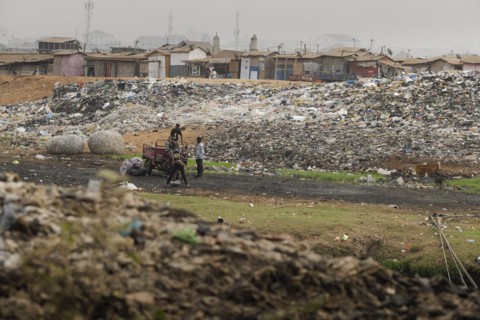 Textile dump in Accra, 21.02.2023. Wild rubbish dump of textile waste where several thousand people live, Accra, Ghana, Africa