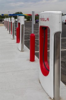 Elkhart, Indiana, Charging stations for Tesla electric vehicles next to a Sunoco gas station on the Indiana Toll Road