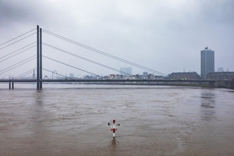 High water on the Rhine in Duesseldorf - Navigation sign at the harbour entrance with view of the Rheinkniebruecke and the old town, Duesseldorf, North Rhine-Westphalia, Germany, Europe