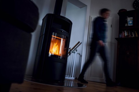 Symbolic photo: A fire burns in a stove in a flat. Berlin, 03.03.2023, Berlin, Germany, Europe