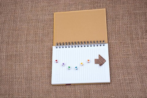 Love cubes and paper arrow on a notebook on canvas