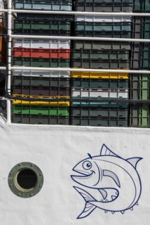 Detail of a white fishing boat with a round porthole