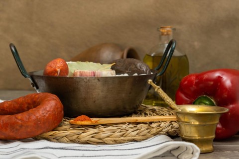 Raw white beans in metal casserole with all the ingredients for cooking them