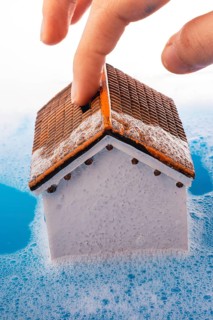 Little model house and a painting brush in foamy water