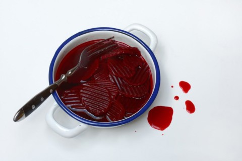 Sliced pickled beetroot with peel and fork