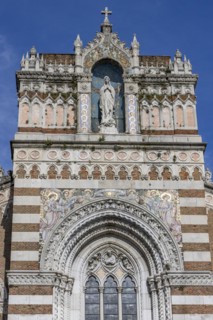 Detail of the top of the facade of the Capuchin Church of Our Lady of Lourdes with a statue of Our Lady of Lourdes decorated with a mosaic