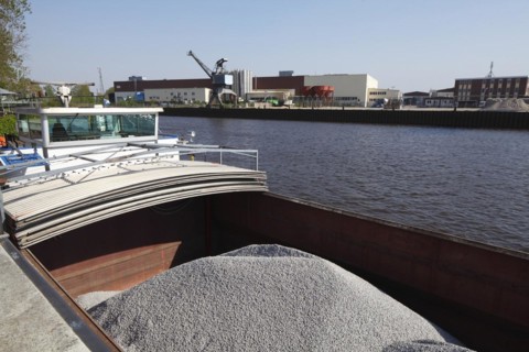 Barge in port loaded with bulk cargo
